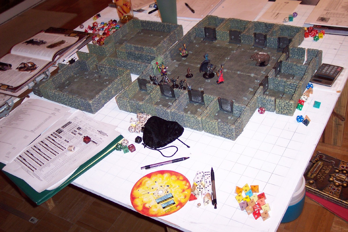 D&D game in progress. Among the gaming aids shown here are dice, a variety of miniatures, and a dungeon diorama.